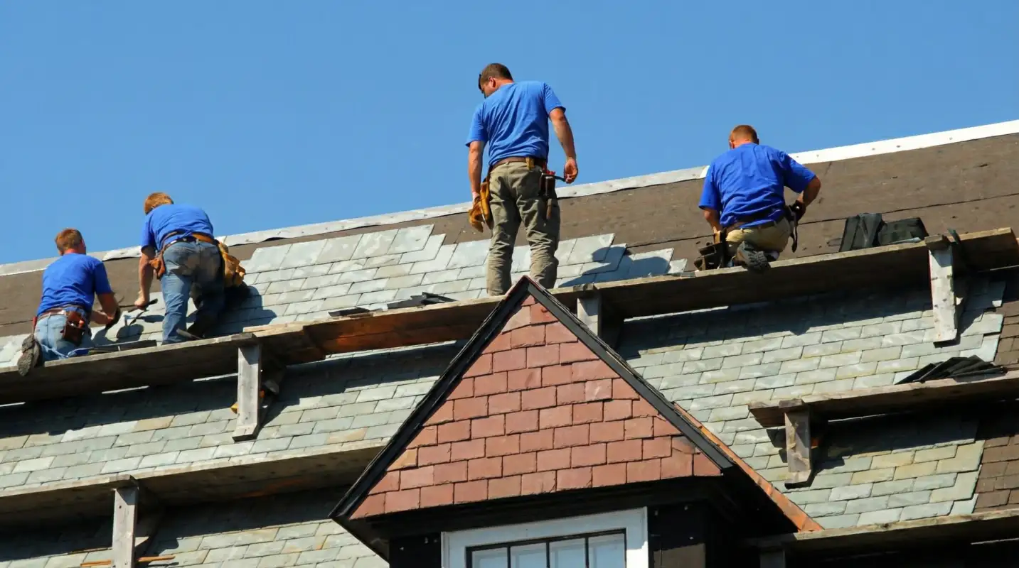 Roof replacement in progress with a team of professional contractors installing new shingles on a residential home in Huntsville, AL